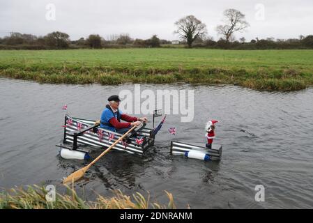 Michael Stanley, bekannt als 'Major Mick', macht seinen Weg entlang des Chichester Kanals, als er seine 70 Meilen Ruderherausforderung in seinem selbstgemachten Boot Tintanic, in Hilfe von St Wilfrid's Hospiz in Bosham beendet. Stockfoto