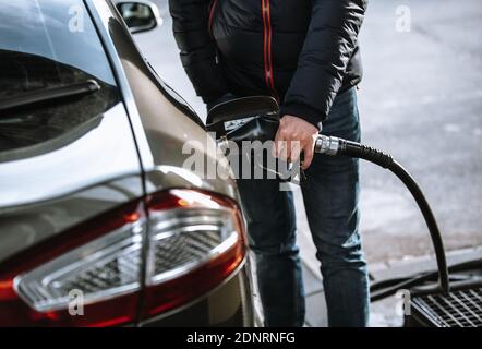 Mann betankt sein Auto in der Gas- oder Tankstelle mit Naphtha oder Öl-Kraftstoff, Betankung Prozess Stockfoto