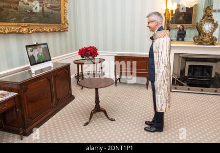 Königin Elizabeth II. Erscheint auf einem Bildschirm mit Videolink aus Windsor Castle, wo sie ihren Wohnsitz hat, während einer virtuellen Audienz, um den Hochkommissar von Neuseeland, Bede Corry, zu empfangen, der am Buckingham Palace in London teilnahm. Stockfoto