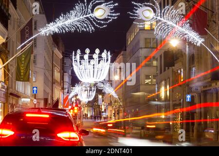 Weihnachtslichter hängen vor den Geschäften über der Bond Street mit Lichtwegen, London West End, England Stockfoto