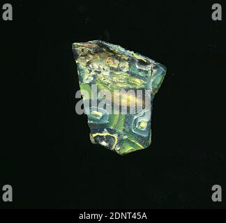 Fragment eines Gefäßes, Glas, gepresst, geschnitten, Gesamt: Höhe: 2.90 cm; Breite: 2.80 cm, Behälter, Lagerung, Küchenarbeit, frühkaiserliche Zeit, EINE leichte Krümmung des Glasfragments sowie der erhaltene Boden ermöglichen die Zuordnung zu einem Gefäß. Verschiedene gelbe, grüne und blaue Linien, Spiralen und Formen sind auf einem grünen bis hellgrünen Hintergrund zu sehen. Für die Herstellung wurden verschiedenfarbige Gläser zu Rohren und Stäben geformt. Diese wurden zusammengedrückt und erhitzt, was zu einer langen Stange führte. Das in Scheiben geschnittene Glas hatte verschiedene amorphe oder florale Muster. Stockfoto