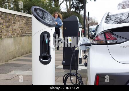 Weißes hyundai-Elektroauto an der Ladestelle angeschlossen Straßenrand in London Stockfoto