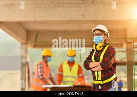 Drei Ingenieure auf einer Baustelle mit Gesichtsmasken, Thailand Stockfoto