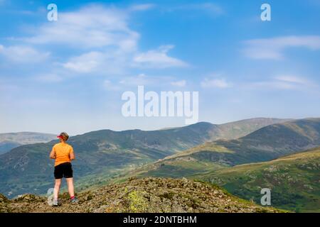 Wanderer mit Blick auf das Fairfield Horseshoe vom Gipfel aus Wansfell Hecht im Lake District Stockfoto