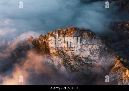 Luftaufnahme eines Bergrückens, der durch die Wolken steigt, Hallein, Salzburg, Österreich Stockfoto