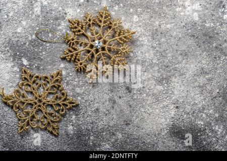 Alte Schneeflocken auf grauem Hintergrund. Neujahr oder Weihnachten Dekorationen Draufsicht Stockfoto