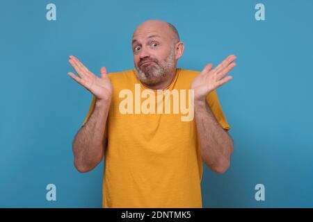 Zweifelhafte kaukasischen Mann fühlen sich am Verlust heben Hände in Verwirrung unsicher über das Problem. Verwirrt Mann zucken Schultern, verwirrt. Studio auf blauem Wal gedreht Stockfoto