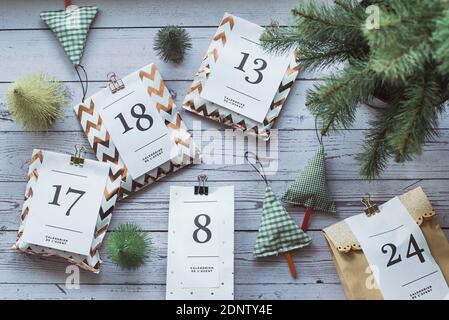 Overhead-Ansicht von Geschenken für einen Adventskalender neben Weihnachtsschmuck Stockfoto