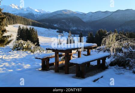 Tisch mit Stühlen im Schnee auf dem Cansiglio Plateau, Italien Stockfoto
