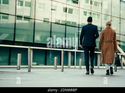 Gemischte Rennen arbeiten Kollegen zusammen zu Fuß ins Büro Chat tragen Elegante Uniform Stockfoto