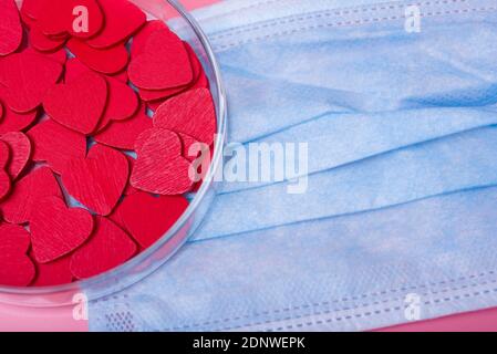 Herz in einer Petrischale auf einem rosa Hintergrund. Das Konzept von Liebe und Glück am Valentinstag. Stockfoto