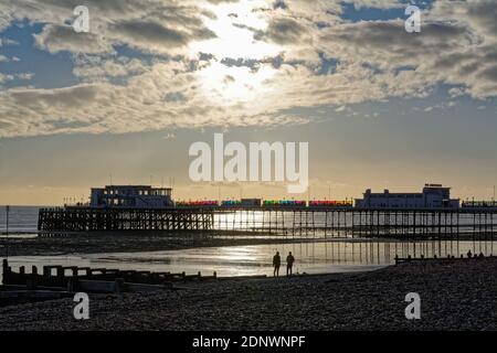 Der Pier in Worthing gegen einen dramatischen Winteruntergang und Wolken Westen Sussex England Großbritannien Stockfoto