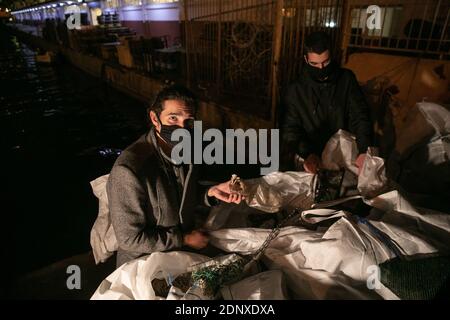 (201218) -- PIRÄUS, 18. Dezember 2020 (Xinhua) -- Lefteris Arapakis (L) und sein Kollege sammeln Plastikmüll von Fischern im Hafen von Keratsini, einem Hafenvorort von Piräus, Griechenland, 17. Dezember 2020. Mit der Vision, das Ökosystem nachhaltig zu gestalten, gründete Lefteris Arapakis 2016 Enaleia, ein soziales Start-up, das Meeresmüll recycelt und aufbereitet. Für seine innovative Idee und konsequente Bemühungen um nachhaltigen Umweltwandel wurde der 26-Jährige Anfang dieser Woche als einer der sieben Young Champions of the Earth des UN-Umweltprogramms (UNEP) für 2020 ausgezeichnet Stockfoto