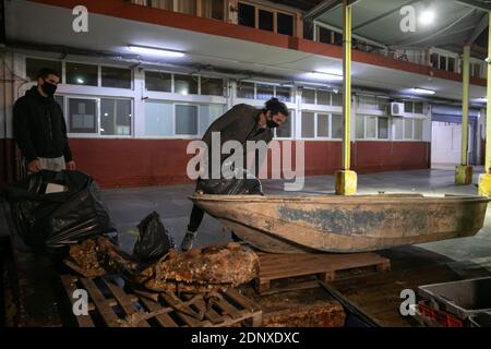 (201218) -- PIRÄUS, 18. Dezember 2020 (Xinhua) -- Lefteris Arapakis (R) und sein Kollege sammeln Plastikmüll von Fischern im Hafen von Keratsini, einem Hafenvorort von Piräus, Griechenland, 17. Dezember 2020. Mit der Vision, das Ökosystem nachhaltig zu gestalten, gründete Lefteris Arapakis 2016 Enaleia, ein soziales Start-up, das Meeresmüll recycelt und aufbereitet. Für seine innovative Idee und konsequente Bemühungen um nachhaltigen Umweltwandel wurde der 26-Jährige Anfang dieser Woche als einer der sieben Young Champions of the Earth des UN-Umweltprogramms (UNEP) für 2020 ausgezeichnet Stockfoto