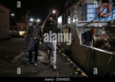 (201218) -- PIRÄUS, 18. Dezember 2020 (Xinhua) -- Lefteris Arapakis (L) und sein Kollege sammeln Plastikmüll von Fischern im Hafen von Keratsini, einem Hafenvorort von Piräus, Griechenland, 17. Dezember 2020. Mit der Vision, das Ökosystem nachhaltig zu gestalten, gründete Lefteris Arapakis 2016 Enaleia, ein soziales Start-up, das Meeresmüll recycelt und aufbereitet. Für seine innovative Idee und konsequente Bemühungen um nachhaltigen Umweltwandel wurde der 26-Jährige Anfang dieser Woche als einer der sieben Young Champions of the Earth des UN-Umweltprogramms (UNEP) für 2020 ausgezeichnet Stockfoto