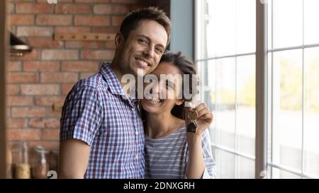 Aufgeregt Millennial Familie Mann und Frau Hausbesitzer kuscheln Vorführung Schlüssel Stockfoto