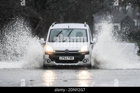 Swansea, Wales, Freitag, 18. Dezember 2020. Wetter: Ein Auto fährt auf einer Straße in Gower, Swansea, durch Hochwasser, da vor dem Wochenende starker Regen über Südwales zu fallen beginnt. In diesem Gebiet wurde eine bernsteinfarbene Wetterwarnung mit Überschwemmungsgefahr ausgegeben. Kredit: Robert Melen. Stockfoto