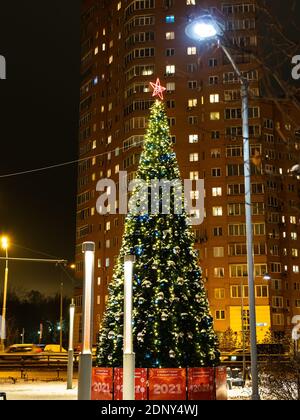 Moskau, Russland - 16. Dezember 2020: Geschmückter und beleuchteter Weihnachtsbaum auf dem Marktplatz in Koptevo Wohnviertel der Stadt Moskau in der Nacht Stockfoto