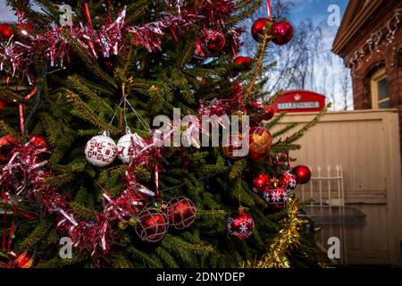 UK, Gloucestershire, Toddington Station, Gloucestershire & Warwickshire Railway Santa Experience, Weihnachtsbaum auf Plattform mit K6-Telefonbox dahinter Stockfoto