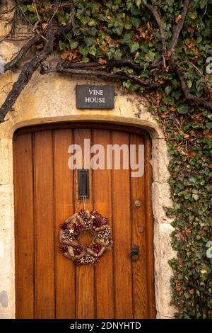 Großbritannien, Gloucestershire, Bourton on the Water, High Street, Weihnachtskranz an der Tür des Vine House Stockfoto