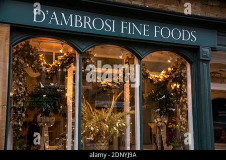 UK, Gloucestershire, Stow on the Wold, High Street, window of D’Ambrosi fine foods shop dressed for Christmas with gold foliage Stock Photo