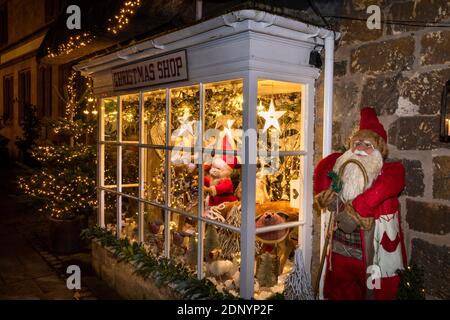 Großbritannien, Gloucestershire, Broadway, High Street, Fenster des Weihnachtsshops am Abend des späten Abendshops im Dezember Stockfoto