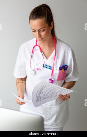 Ärztin beim Lesen der Krankenakten im Büro Stockfoto