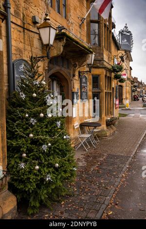 Großbritannien, Gloucestershire, Moreton in Marsh, High Street, Weihnachtsbaum und Dekorationen außerhalb Swan Inn Stockfoto