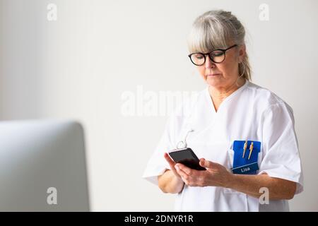 Arzt überprüft ihr Handy Stockfoto