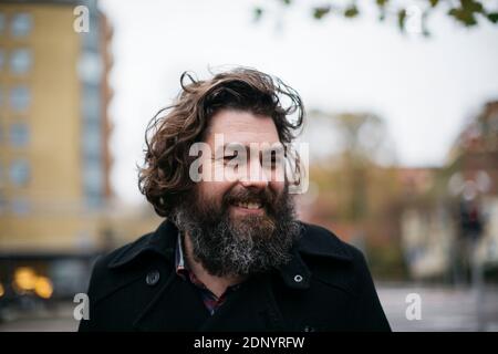 Bärtiger Mann lächelnd im freien Stockfoto