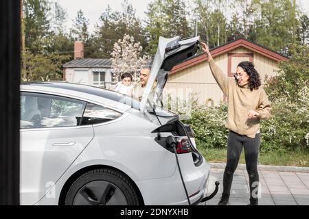 Frau, die den Kofferraum schließt Stockfoto
