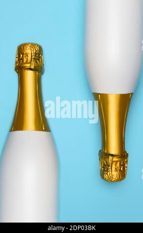 Zwei weiße Champagner-Flaschen auf blauem blauem blauem Hintergrund. Vertikaler High-Angle-Shot. Stockfoto
