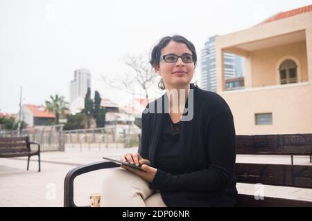 Lächelnde Frau sitzen auf Bank Stockfoto