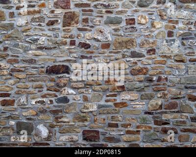 Teil einer alten Steinmauer, mit Mörtel spitz, für Hintergrund oder Textur. Stockfoto