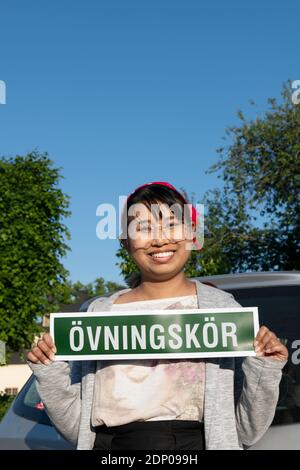 Studentinnen-Fahrer mit Schild Stockfoto