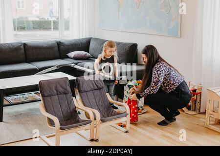 Smiling girl vacuum cleaning living room Stock Photo