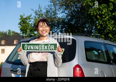 Studentinnen-Fahrer mit Schild Stockfoto
