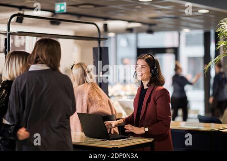 Lächelnde Frau an der Rezeption Stockfoto