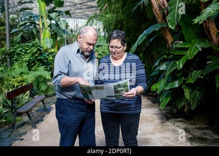 Couple reading leaflet in botanical garden Stock Photo