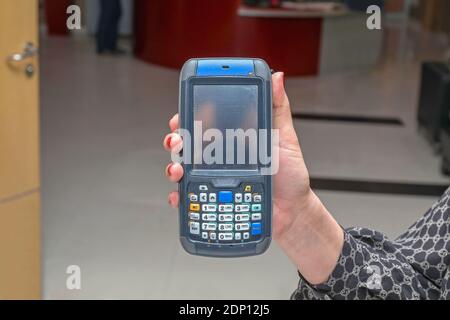 Frau hält tragbaren Barcode-Scanner und RFID-Reader-Gerät Stockfoto