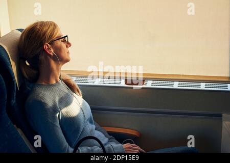 Woman relaxing in train Stock Photo