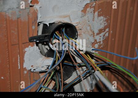 Elektroarbeiten in einem neuen Gebäude Kabel kommen aus Die Wand Stockfoto