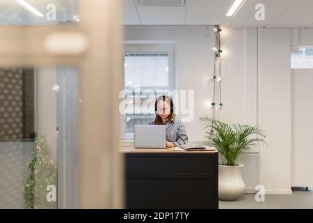 Frau mit Headset im Büro Stockfoto