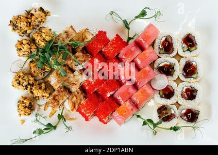 Japanische Sushi-Sets auf weißem Teller und schwarzem Hintergrund Stockfoto