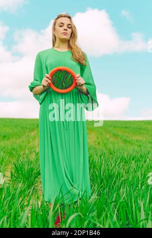 Portrait der jungen Frau trägt grünes Kleid auf einem stehen Reflektierender Außenspiegel Stockfoto