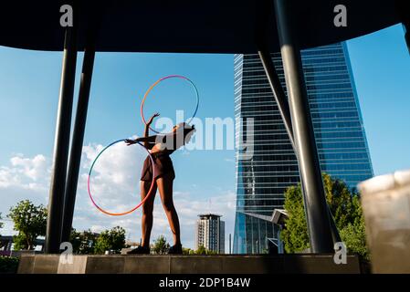 Sportliche Frau trainieren mit Kunststoff-Reifen in der modernen Stadt Stockfoto