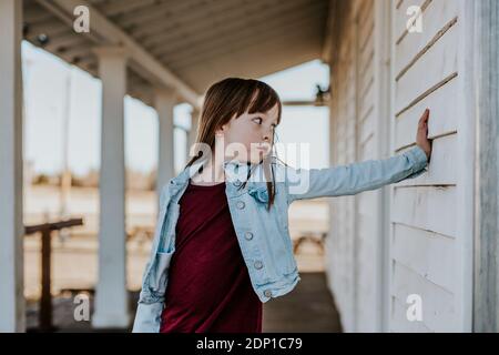 Junges Mädchen auf der Terrasse stehen und ein dummes Gesicht machen Stockfoto