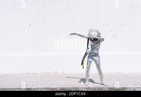 Junge im Astronaut Kostüm Dabbing Bewegung, während Sie gegen die Wand stehen Stockfoto