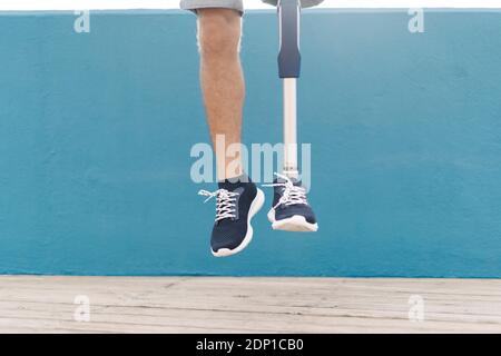 Behinderter Mann, der gegen die blaue Wand springt Stockfoto