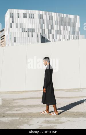 Junger Mann mit schwarzem Kaftan im Freien Stockfoto